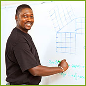 Photo of a teacher at a whiteboard.