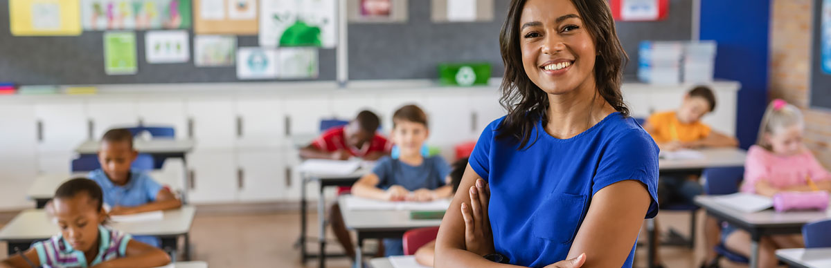 Student looking in microscope while teacher watches