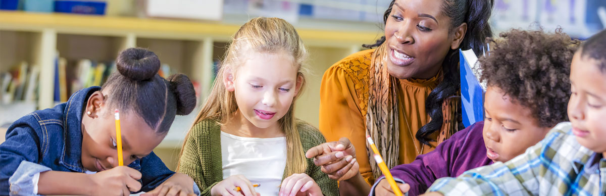 Student looking in microscope while teacher watches