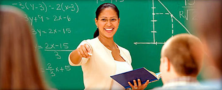 Math teacher lecturing in front of a chalk board