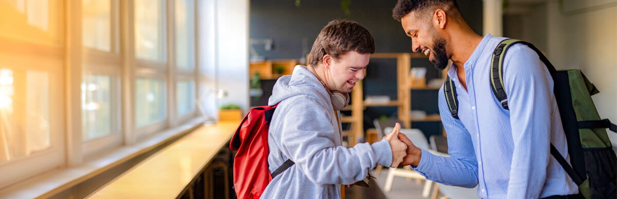 Student looking in microscope while teacher watches